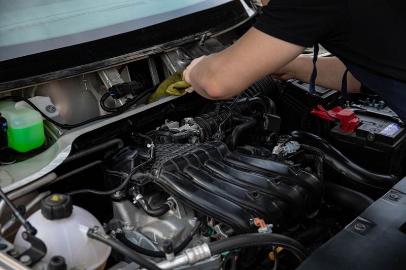 Close-up of a mechanic's hands working deep in an engine bay