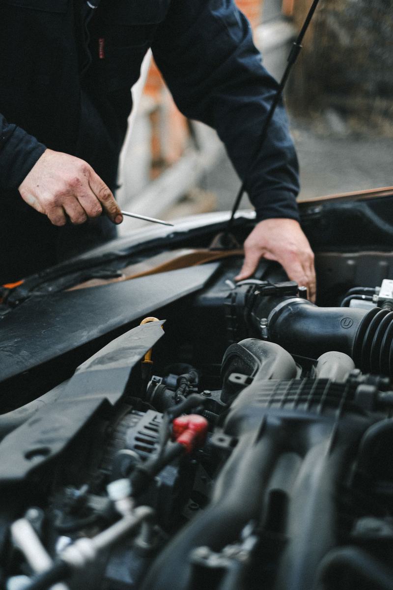 Mechanic pulling a dipstick to check the oil on an engine