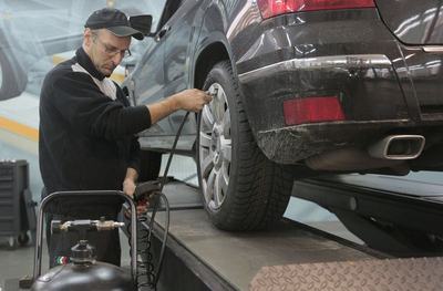 Mechanic checking a wheel on a car raised on a lift